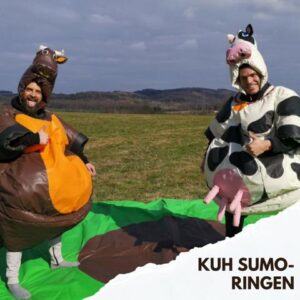 Zwei Teilnehmer in Kuh-Sumo-Kostümen beim humorvollen Wettkampf für hohe Event-Dynamik.